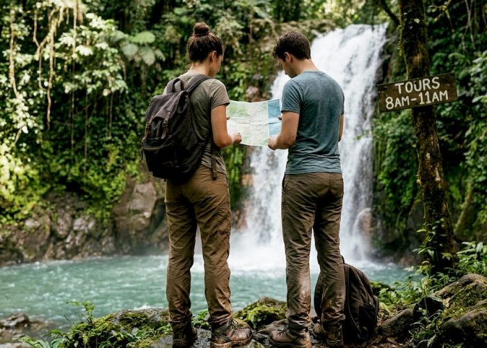 Couple planning waterfall tour by rainforest