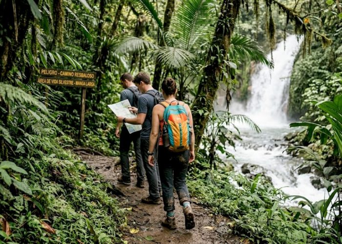 Adventurers hiking beside Costa Rican waterfall